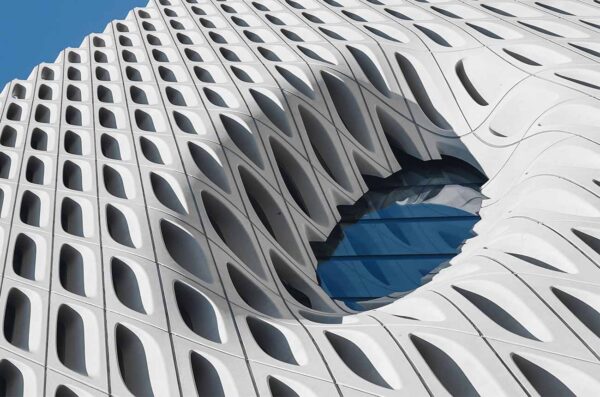 Close-up of a modern architectural facade with a circular blue window.
