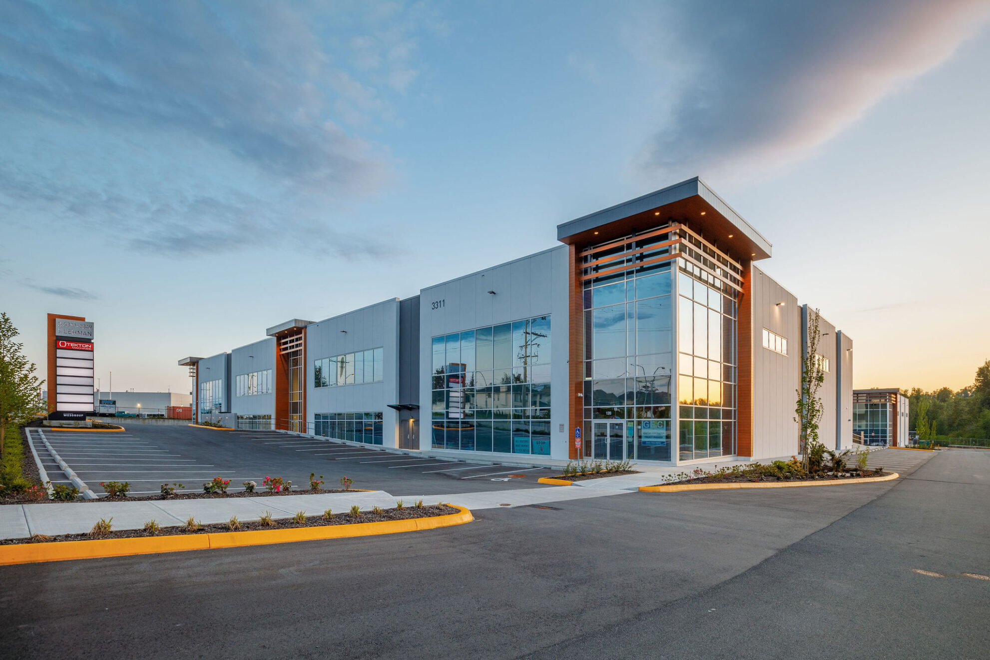 Modern commercial building with large glass windows during sunset.